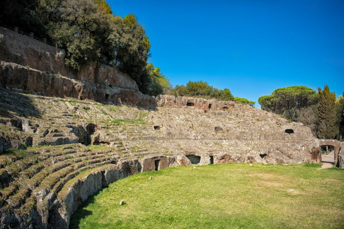 Scopri l’antico fascino dell’anfiteatro romano di Sutri, interamente scavato nella roccia. Un sito archeologico immerso nel verde.