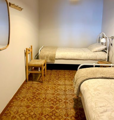 Camera da letto con due letti singoli, arredo semplice e atmosfera rilassante.